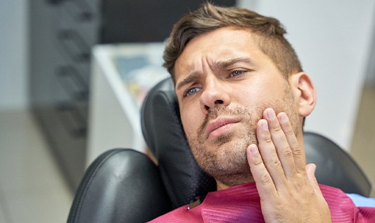 Patient with toothache sitting in treatment chair