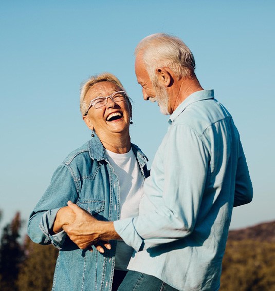 Happy couple smiling together after affording the cost of dentures in Des Plaines