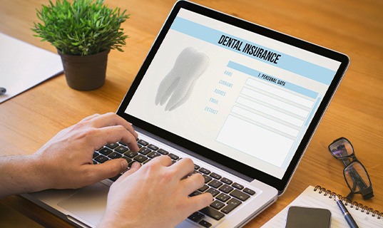 Patient filling out dental insurance form on computer