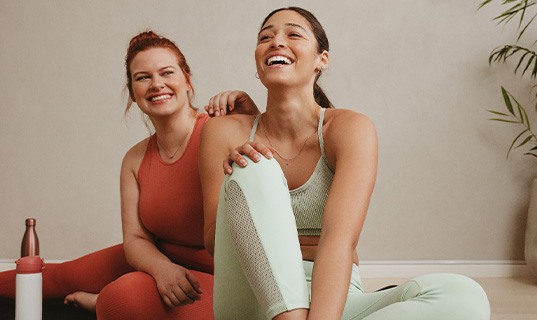 Two friends smiling in exercise class
