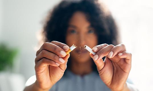 Closeup of woman breaking cigarette