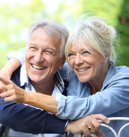 Senior couple hugging and looking over a fence