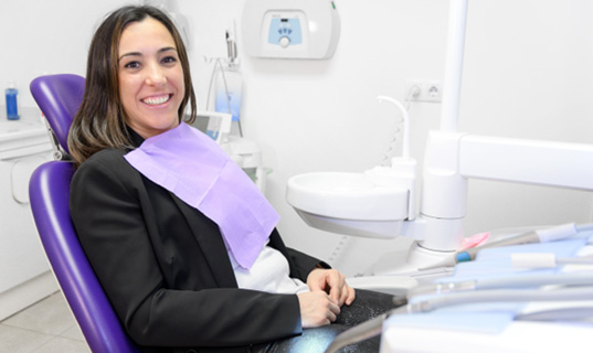 Woman sitting in dental chair smiling