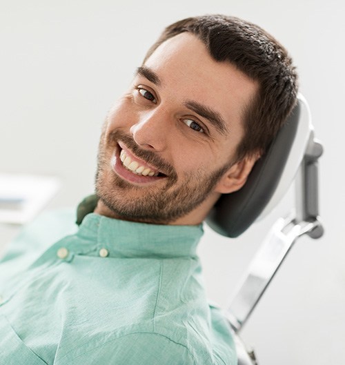 A smiling man laying in a dentist’s chair
