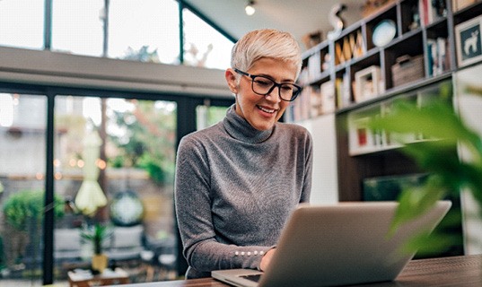 Senior woman smiling while working at home