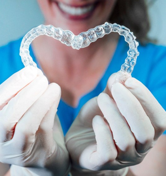 Invisalign aligner held in the shape of a heart