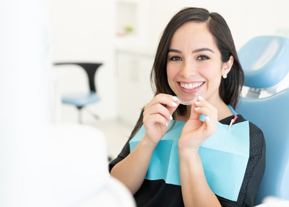 Patient in Mount Prospect holding Invisalign aligner