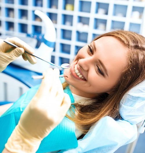 a patient smiling while visiting her dentist