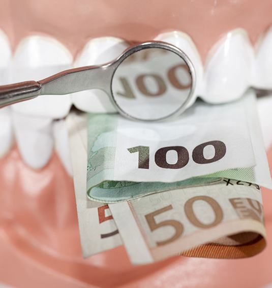 A wad of cash clenched in a set of teeth