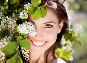 Woman outside smiling among some spring flowers