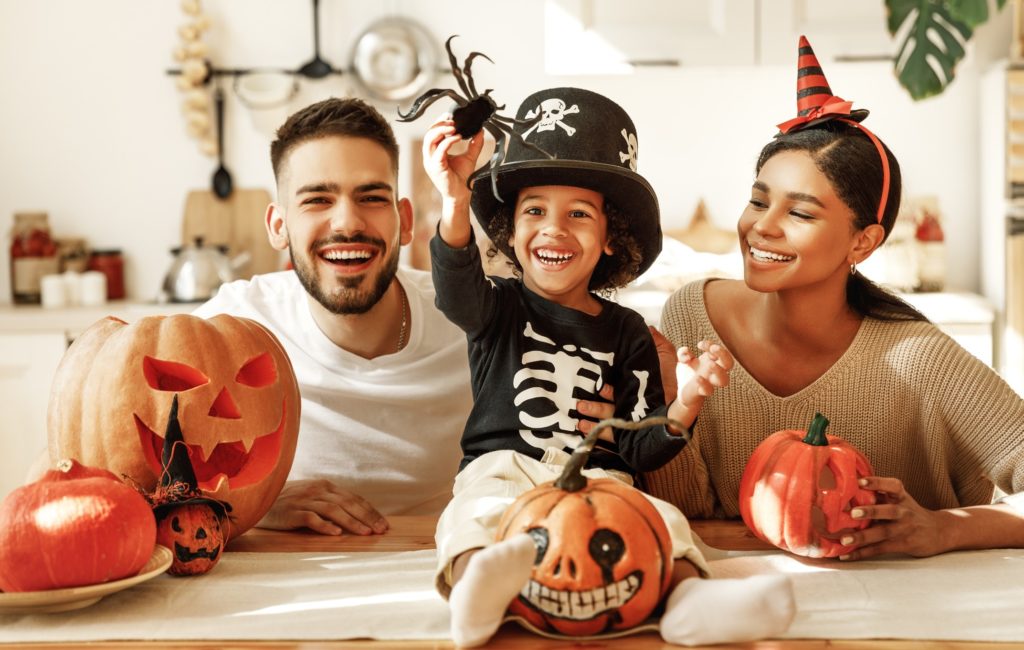 Family smiling with Halloween decorations at home