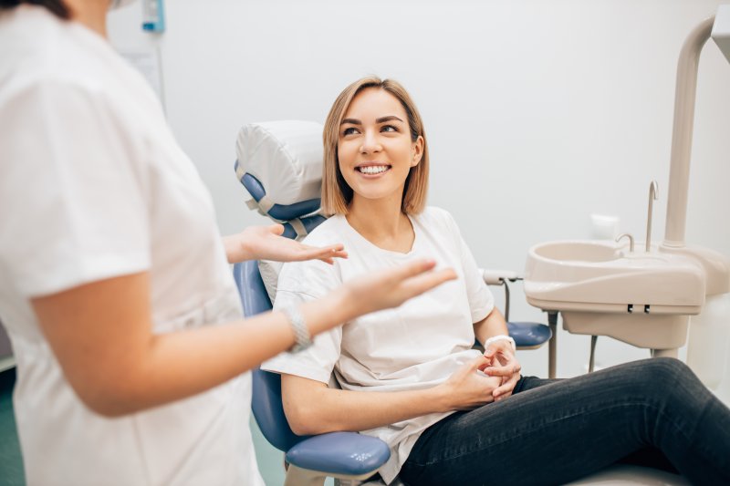 Dentist explaining something to woman in dental chair