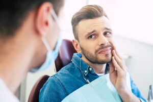Patient in dentist’s chair with worried look.
