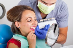 Dentist helping patient try out different shades of veneers.